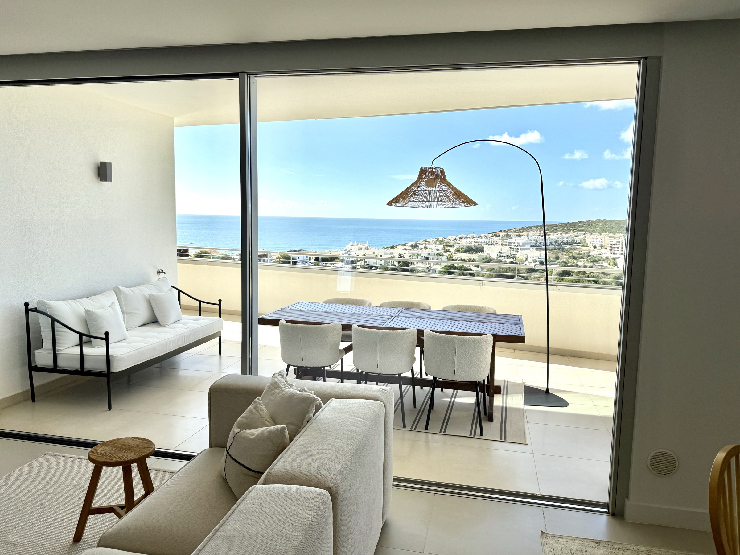 Living room framing the terrace dining area and ocean view