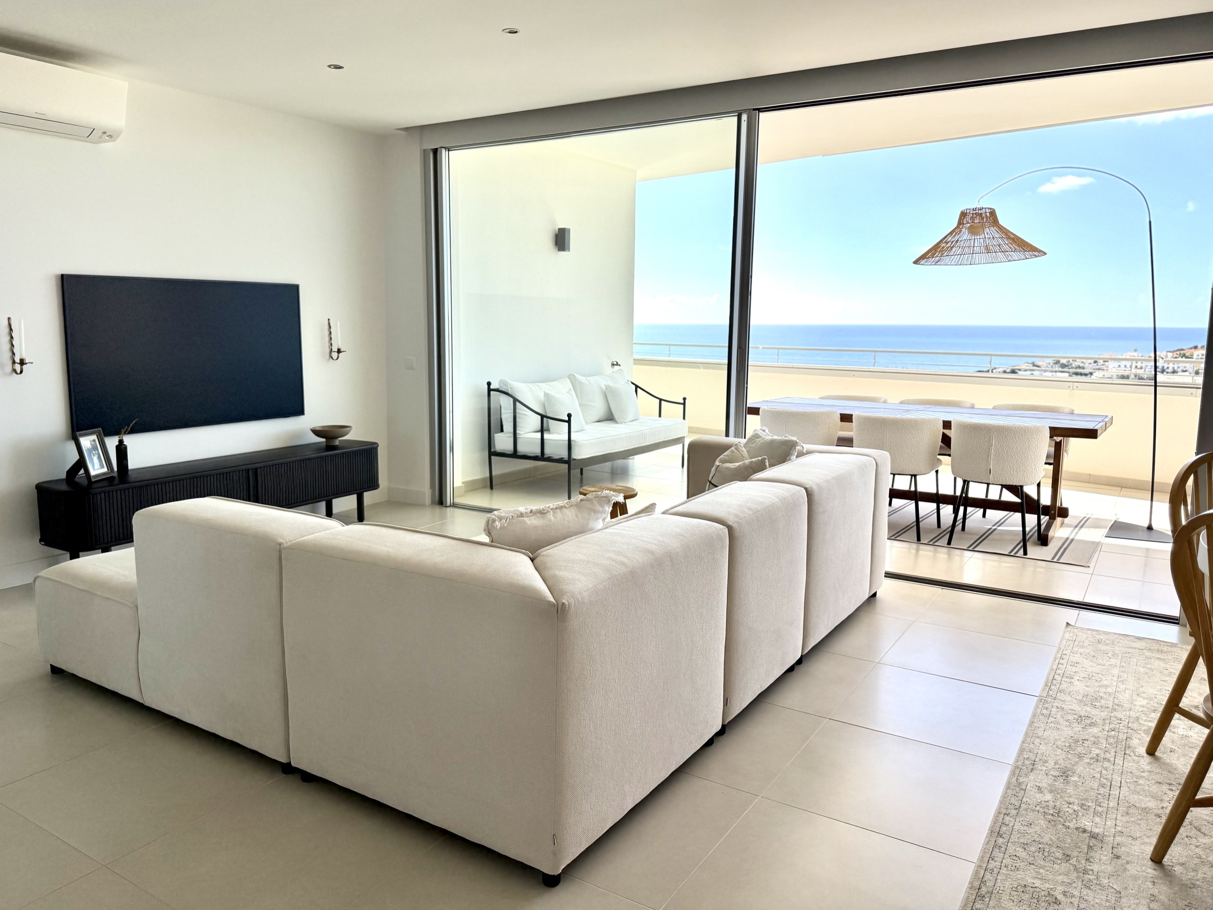 Living room opening fully to ocean-facing terrace